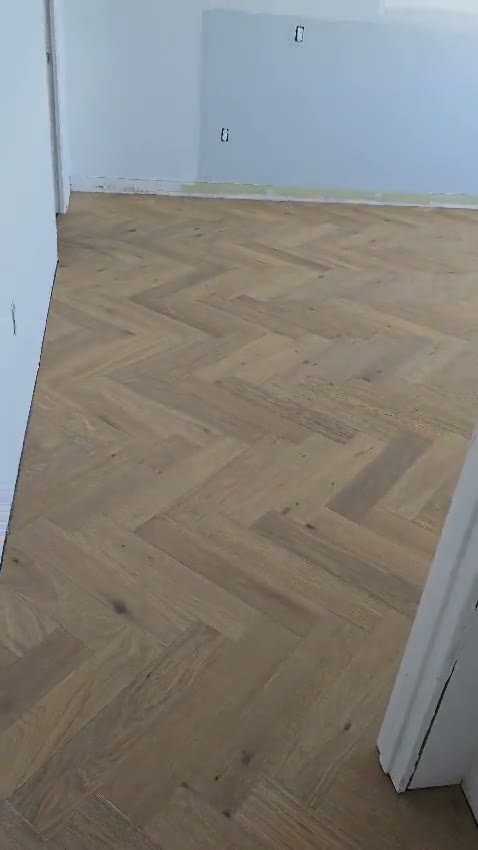 Walkthrough video of a room with a new herringbone wood floor