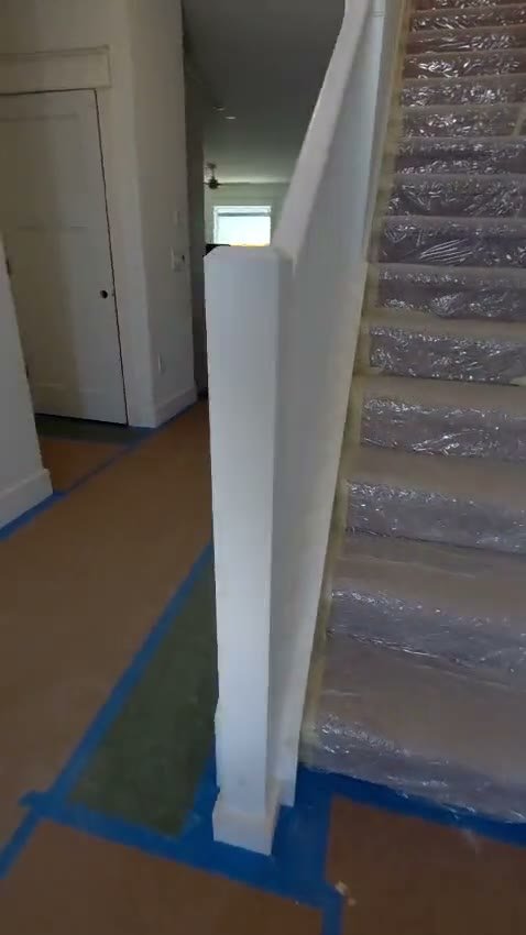 Video of a white painted stair railing with protective covering on the steps